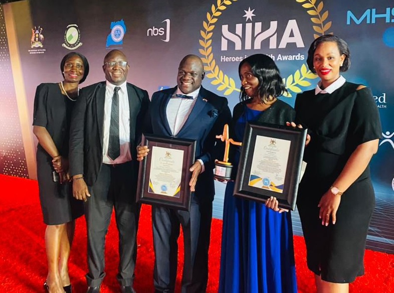 Group smiling with awards at the awards ceremony